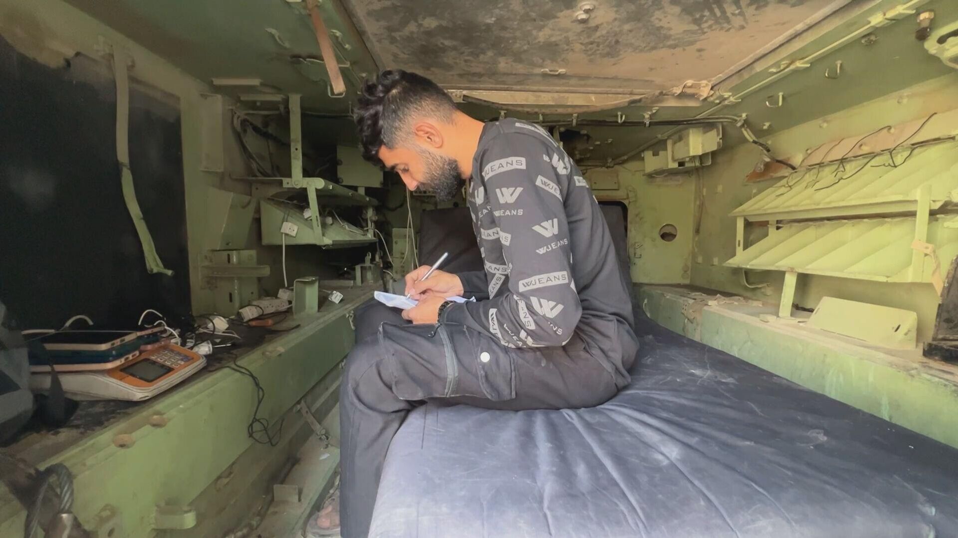 فلسطيني يحول بقايا مدرعة إسرائيلية إلى محطة شحن هواتف في غزة - سبوتنيك عربي, 1920, 05.12.2025