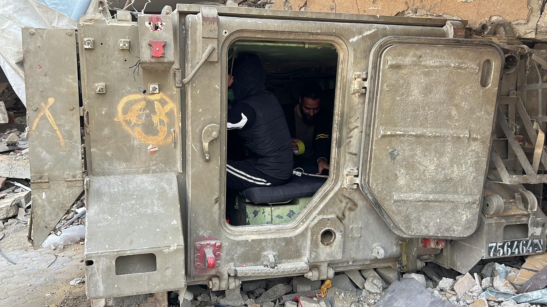 فلسطيني يحول بقايا مدرعة إسرائيلية إلى محطة شحن هواتف في غزة - سبوتنيك عربي, 1920, 05.12.2025