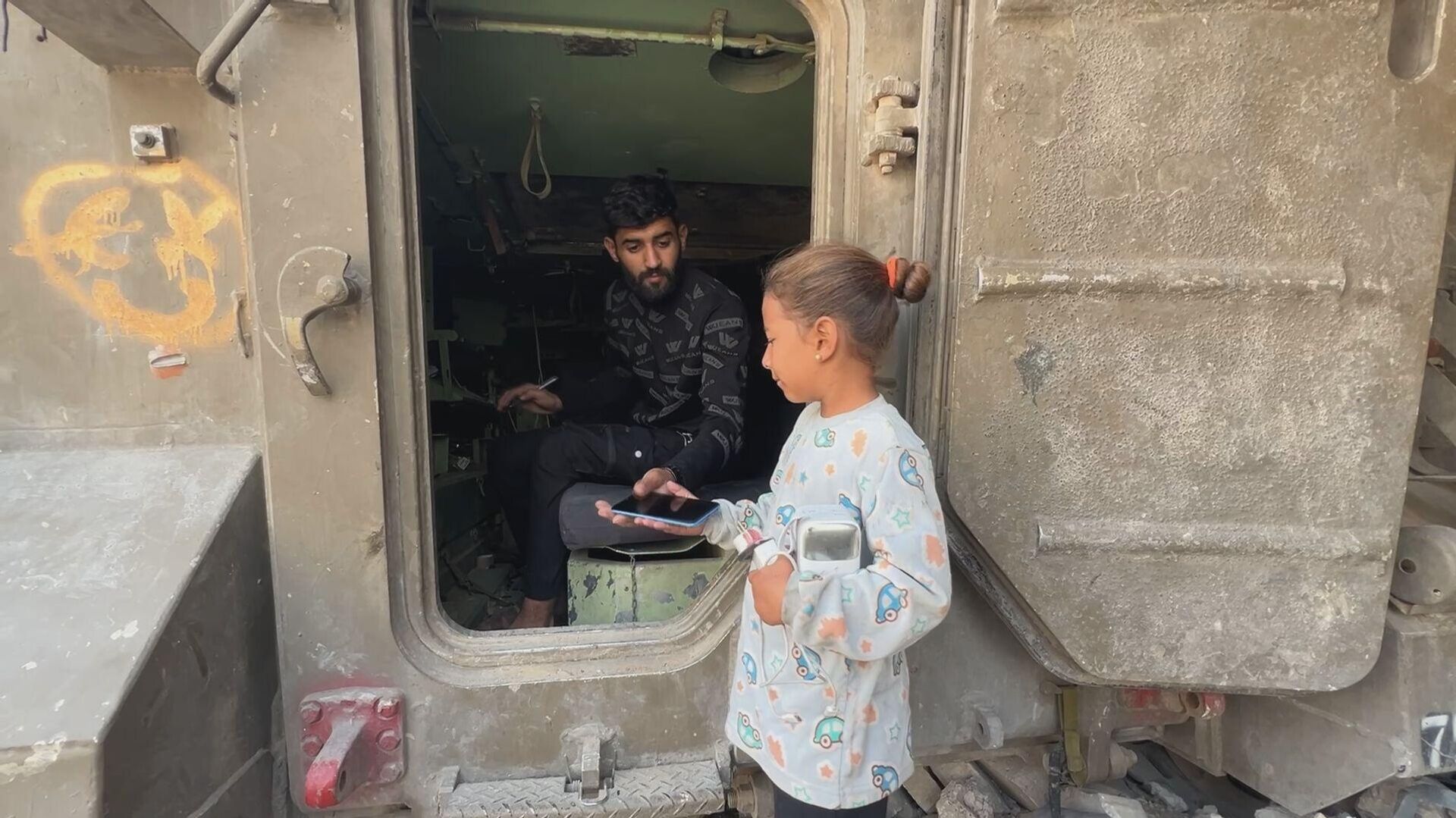 فلسطيني يحول بقايا مدرعة إسرائيلية إلى محطة شحن هواتف في غزة - سبوتنيك عربي, 1920, 05.12.2025