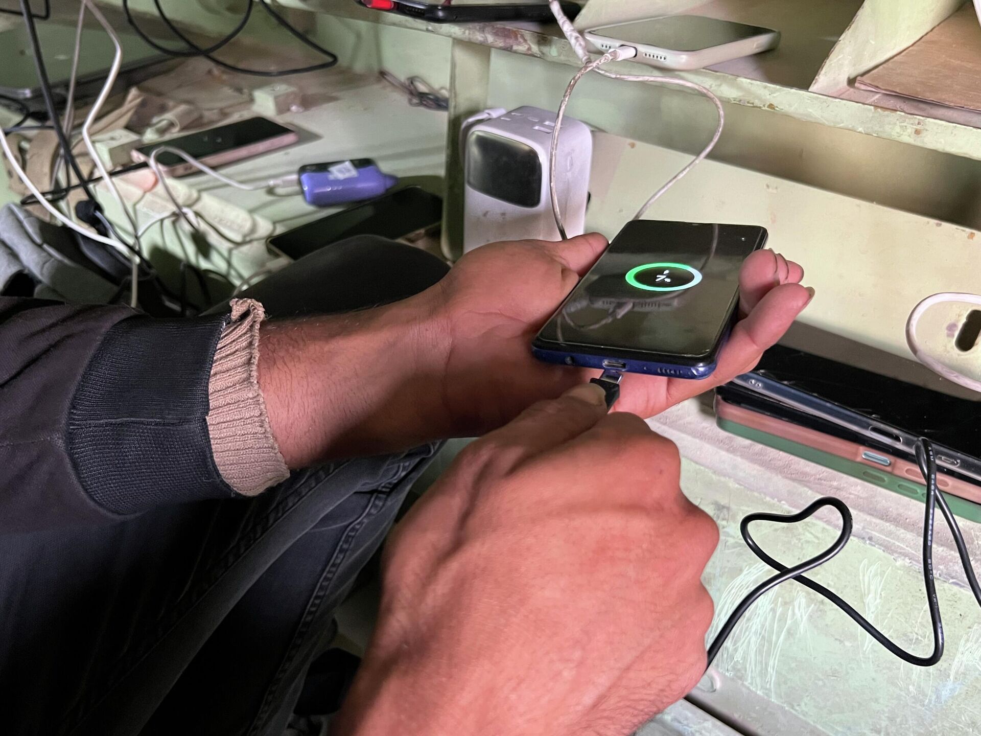 فلسطيني يحول بقايا مدرعة إسرائيلية إلى محطة شحن هواتف في غزة - سبوتنيك عربي, 1920, 05.12.2025