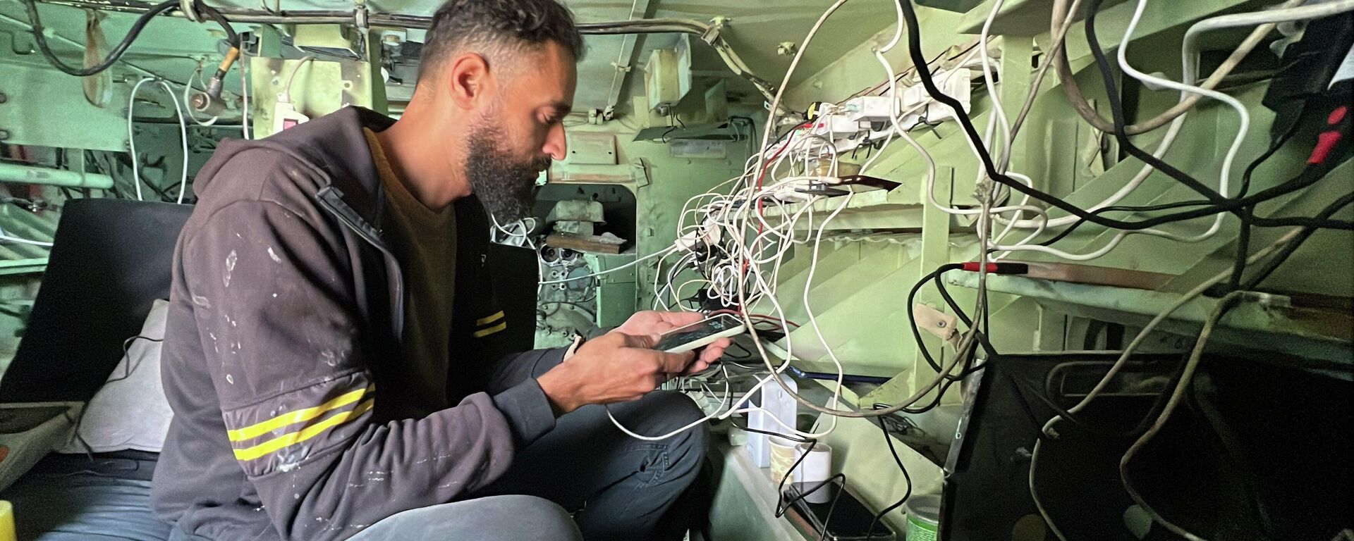 فلسطيني يحول بقايا مدرعة إسرائيلية إلى محطة شحن هواتف في غزة - سبوتنيك عربي, 1920, 05.12.2025