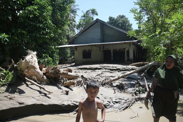 صورة تظهر طفلا، يقف أمام منزل متضرر جراء الفيضانات في بيدي جايا، أندونيسيا. - سبوتنيك عربي