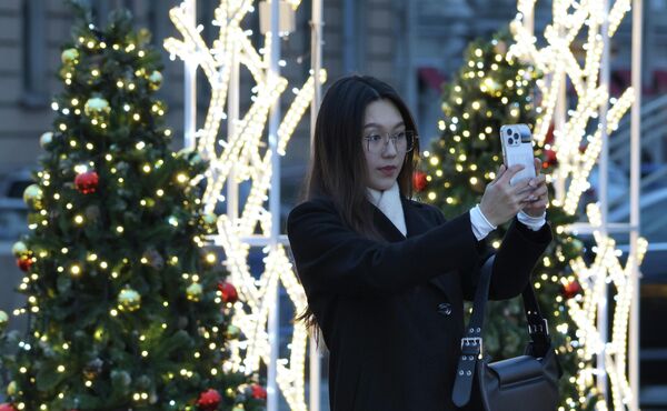 فتاة تلتقط صورة في الشارع على خلفية زينة رأس السنة الجديدة في سانت بطرسبرغ. فتاة تلتقط صورة في الشارع على خلفية زينة رأس السنة الجديدة في سانت بطرسبرغ. - سبوتنيك عربي