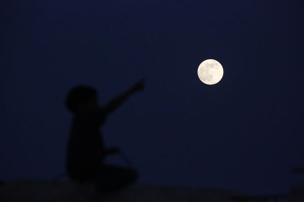 القمر العملاق &quot;البارد&quot; فوق المغراقة في وسط غزة، التي عانت من دمار واسع بسبب الحرب - سبوتنيك عربي