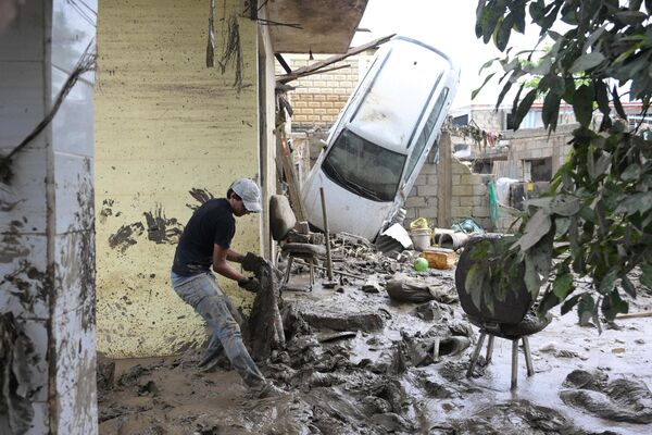صورة تظهر رجلا يقوم بإزالة الطين في إحدى المناطق المتضررة من الأمطار الغزيرة التي هطلت في المكسيك. - سبوتنيك عربي