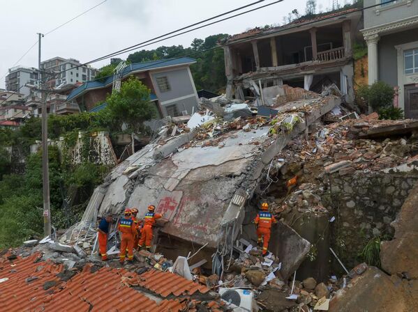 صورة تظهر رجال الإنقاذ من موقع انهيارأحد المباني، الذي نجم عن هطول الأمطار الغزيرة في قرية دايوان، في الصين. - سبوتنيك عربي