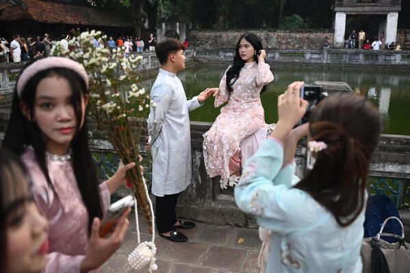 صورة لبعض الزائرين من داخل معبد الأدب في هانوي، في فيتنام، وتظهر الصورة شاب وشابة(عرسان)، في وضعية جميلة، لكي يتم التقاط صورة لهما. - سبوتنيك عربي