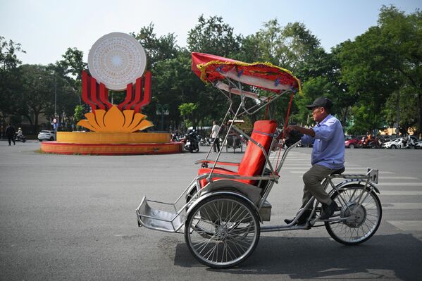صورة لأحد سكان مدينة هانوي، في فيتنام، وهو يقود دراجته الهوائية الطريفة، حيث يقود الدراجة من الجهة الخلفية، وفي الجهة الأمامية يوجد كرسي ذو مقعد أحمراللون للجلوس.                                                                                                                                                                                                                                                                                                                                                                                                                                                                                                                                                                                                                                                                                                                                                            - سبوتنيك عربي