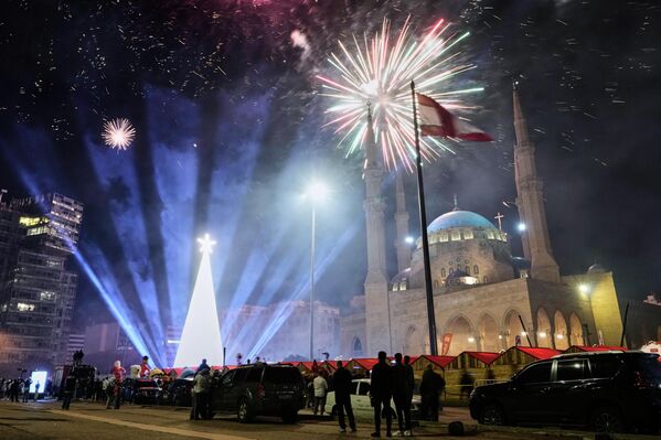 يشاهد الناس الألعاب النارية خلال إضاءة شجرة عيد الميلاد العملاقة التي أقيمت أمام مسجد محمد الأمين في ساحة الشهداء في بيروت، لبنان. - سبوتنيك عربي