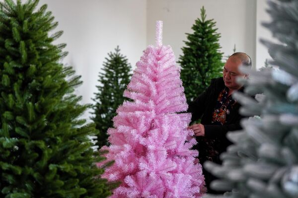 عامل يعمل على خط إنتاج أشجار عيد الميلاد في ورشة عمل بمدينة جينهوا، مقاطعة تشجيانغ الصينية. - سبوتنيك عربي