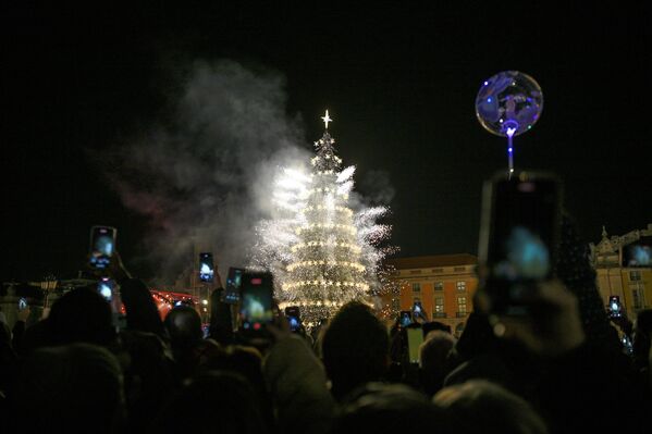 احتشاد جمع غفير لمشاهدة إضاءة شجرة عيد الميلاد الشهيرة التي يبلغ ارتفاعها 30 مترا، بالإضافة إلى عروض الألعاب النارية في ساحة التجارة في لشبونة، البرتغال. وتغطي الأضواء هذا العام مسافة إجمالية قدرها 182كيلومتراً، موزعة على 46 موقعاً، تشمل ساحات وشوارع وجادات. - سبوتنيك عربي