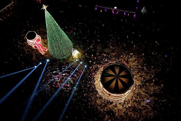 تضيء العاصمة الألبانية شجرة عيد الميلاد في ساحة سكاندربغ في تيرانا، بينما يتجمع الناس للاستماع إلى حفل موسيقي. - سبوتنيك عربي