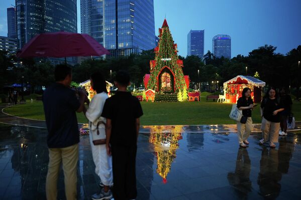 &quot;يتجول المارة أمام شجرة عيد الميلاد المزينة في إحدى الحدائق بمدينة جاكرتا، إندونيسيا. - سبوتنيك عربي