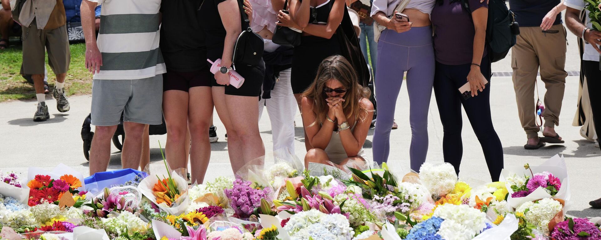 يتجمع الناس حول باقة زهور متنامية تكريماً لضحايا إطلاق النار خارج جناح بوندي في شاطئ بوندي بسيدني أستراليا، يوم الاثنين 15 ديسمبر/كانون الأول 2025، بعد يوم من وقوع حادث إطلاق نار. - سبوتنيك عربي, 1920, 15.12.2025