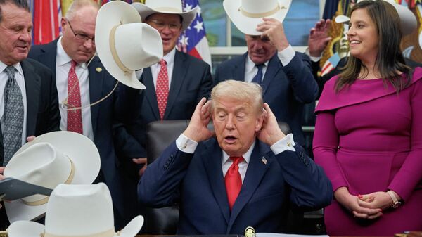 صورة للرئيس الأمريكي دونالد ترامب، وهو يصفف شعره مازحًا، لالتقاط صورة مع أعضاء فريق الهوكي الأولمبي الأمريكي للرجال، في البيت الأبيض، وإلى يمينه النائبة إليز ستيفانيك، الجمهورية عن ولاية نيويورك. - سبوتنيك عربي