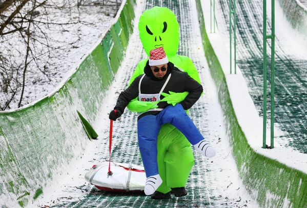 أحد المشاركين في مهرجان "ماش أون ذا هيل" السنوي للتزلج، في الذكرى الخمسين لتأسيس حديقة "أكتوبر"، ويظهر في الصورة قيام شخص يرتدي لباسا أخضر اللون يقوم باحتضان المشارك. - سبوتنيك عربي