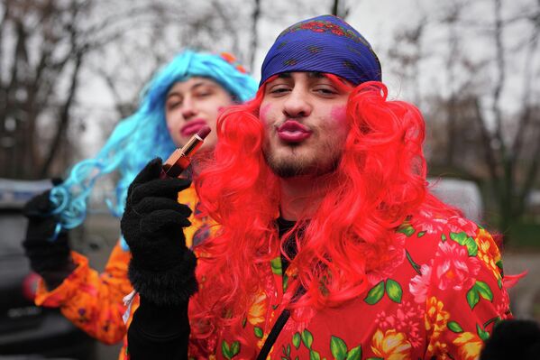 أعضاء فرق "الفلكلور"، يظهرون بوضعيات طريفة، أثناء وضعهم للمكياج قبل مهرجان تقاليد عيد الميلاد ورأس السنة الجديدة في متحف قرية "دميتري غوستي الوطني"، في بوخارست، رومانيا. - سبوتنيك عربي