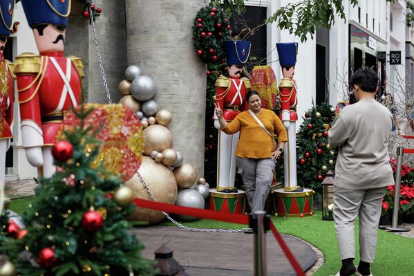 يلتقط الزوار صورا تذكارية أمام زينة عيد الميلاد الاحتفالية في مركز باريس فان جافا التجاري (PVJ) في إندونيسيا - سبوتنيك عربي