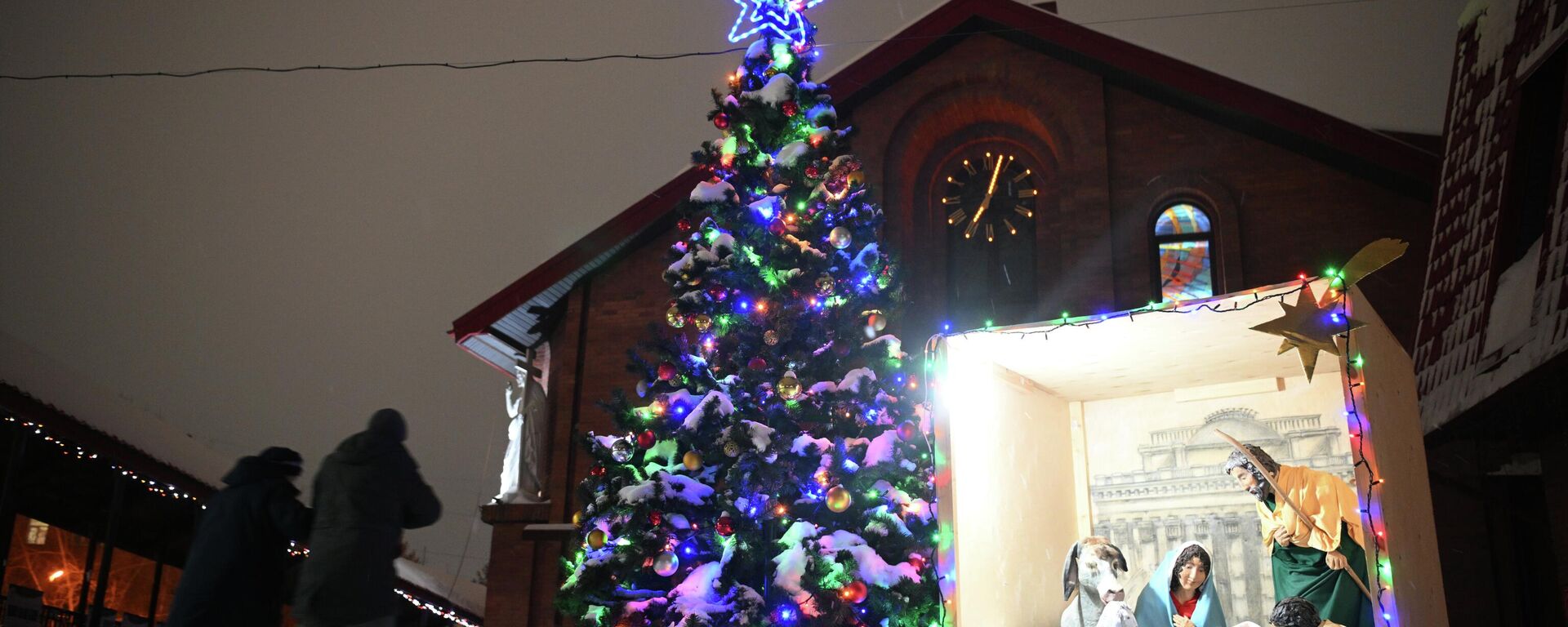 شجرة عيد الميلاد عند مدخل الكاتدرائية الكاثوليكية في نوفوسيبيرسك في روسيا - سبوتنيك عربي, 1920, 25.12.2025