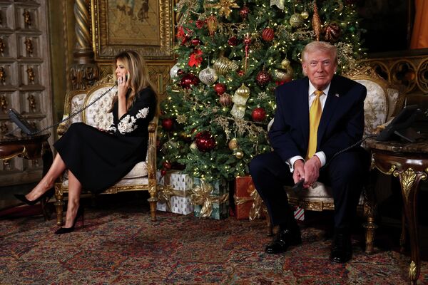 الرئيس الأمريكي دونالد ترامب وزوجته ميلانيا ترامب، يهنئان الأطفال أثناء مشاركتهما في تتبع تحركات "سانتا كلوز" - سبوتنيك عربي