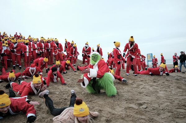 يتحدى راكبو الأمواج الذين يرتدون ملابس سانتا كلوز المياه الجليدية لبحر الشمال خلال حدث سانتاس السنوي لركوب الأمواج في شيفينينغن في هولندا. يشارك أكثر من مئة مشارك، ويملأون الشاطئ الشتوي ببدلات حمراء ولحى بيضاء - سبوتنيك عربي