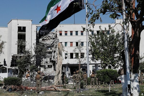 جنود سوريون يرفعون العلم السوري أمام مبنى وزارة الدفاع في العاصمة دمشق، عقب الضربة الإسرائيلية التي طالت المبنى - سبوتنيك عربي