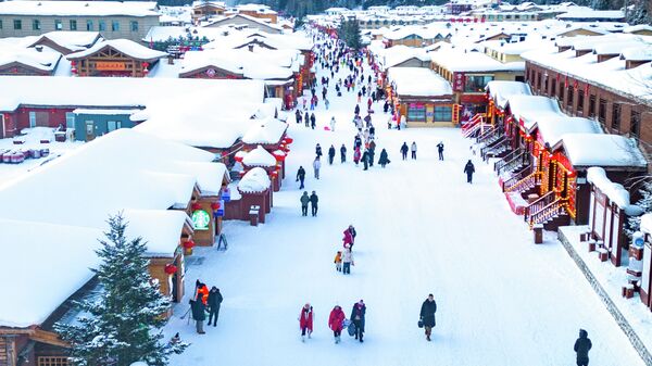 صورة جوية لسياح يزورون مدينة الثلج الصينية، إحدى أشهر وجهات السياحة الجليدية والثلجية في مقاطعة هيلونغجيانغ في الصين - سبوتنيك عربي