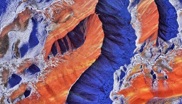 صورة جوية لمنطقة تشيتساي دانشيا السياحية مغطاة بالثلوج المتساقطة في مدينة تشانغيه في مقاطعة قانسو الصينية - سبوتنيك عربي