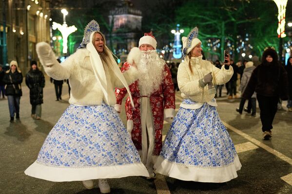 صورة تظهر أشخاص يرتدون أزياء ديد موروز ( بابا نويل الروسي)، وسنيغوروتشكا (فتاة الثلج) وهم يسيرون احتفالاً برأس السنة في سان بطرسبورغ، روسيا. - سبوتنيك عربي