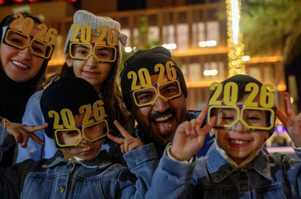 صورة تظهر أبا مع عائلته وهم يرتدون أقنعة رأس السنة ونتظهر ابتسامتهم السعيدة اثناء الاحتفالات في فعاليات رأس السنة في الدوحة، قطر. - سبوتنيك عربي