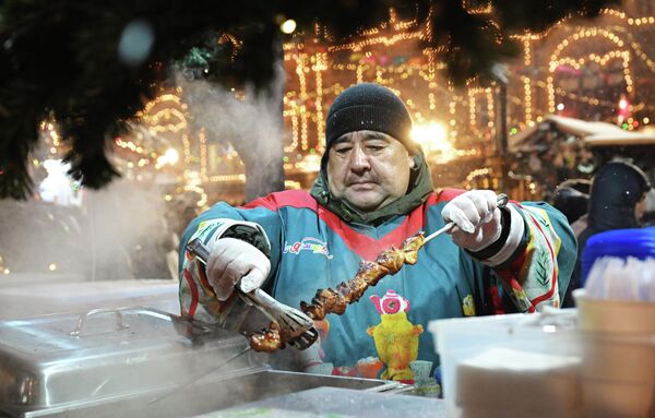 رجل يُعدّ "الشاشليك" في معرض "غوم" بمناسبة رأس السنة في الساحة الحمراء بموسكو. - سبوتنيك عربي