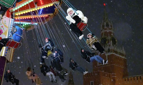 أشخاص يستمتعون بركوب لعبة الدوامة في الساحة الحمراء. - سبوتنيك عربي