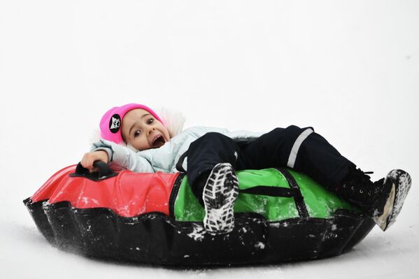 طفل يستلقي على طوافة مطاطية وسط الجليد. - سبوتنيك عربي