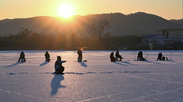 شروق الشمس في مهرجان صيد الأسماك الشتوي لكأس العمدة كول سميلت يصطادون السمك بالملعقة في خليج برازنيكوف في فلاديفوستوك. - سبوتنيك عربي