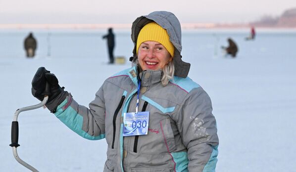 مشاركة في مهرجان صيد الأسماك الشتوي لكأس العمدة "كول سميلت"، وهي تبتسم مسرورة في صيد الأسماك على الجليد في خليج برازنيكوف في فلاديفوستوك. - سبوتنيك عربي