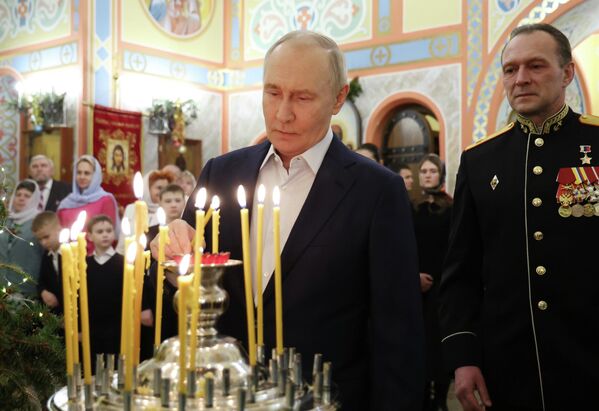 الرئيس الروسي فلاديمير بوتين، وأفراد من القوات المسلحة الروسية مع عائلاتهم خلال قداس بمناسبة ميلاد المسيح في كنيسة الشهيد العظيم جرجس المنتصر في مدينة سولنيشنوغورسك-2 في مقاطعة موسكو - سبوتنيك عربي