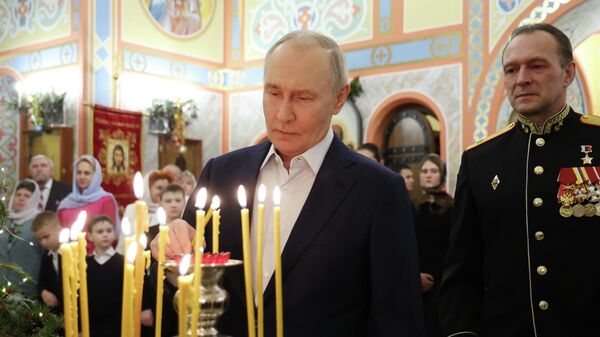 الرئيس الروسي فلاديمير بوتين، وأفراد من القوات المسلحة  الروسية مع عائلاتهم خلال قداس بمناسبة ميلاد المسيح في كنيسة الشهيد العظيم جرجس المنتصر في مدينة سولنيشنوغورسك-2 في مقاطعة موسكو. - سبوتنيك عربي