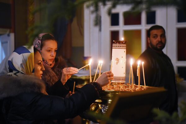 الناس خلال قداس عيد الميلاد في كاتدرائية الصعود في ألماتي في كازاخستان - سبوتنيك عربي