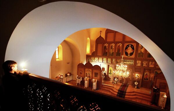 قداس عيد الميلاد المسائي في كنيسة لقاء أيقونة فلاديمير للسيدة العذراء مريم التابعة للكنيسة الأرثوذكسية الروسية القديمة في كراسنويارسك في روسيا  - سبوتنيك عربي