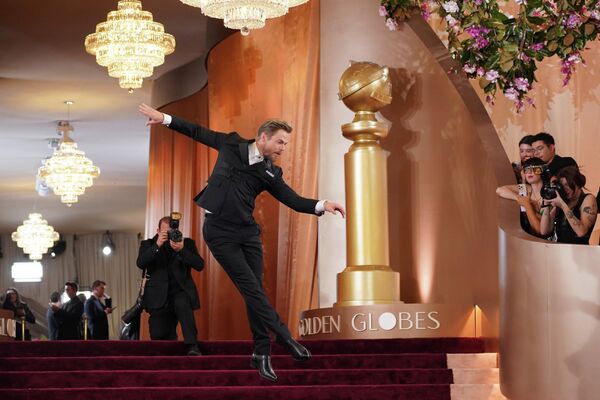 صورة توثق حركة استعراضية يقوم بها ديريك هوف أثناء دخوله فندق بيفرلي الذي يقام فيه حفل توزيع الجوائز. - سبوتنيك عربي