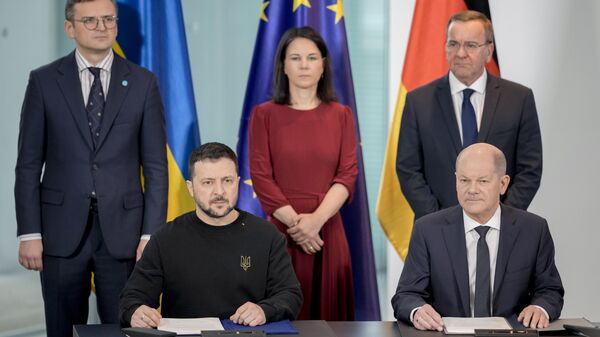 German Chancellor Olaf Scholz and Ukrainian President Volodymyr Zelensky sign a treaty in the chancellory in Berlin - سبوتنيك عربي