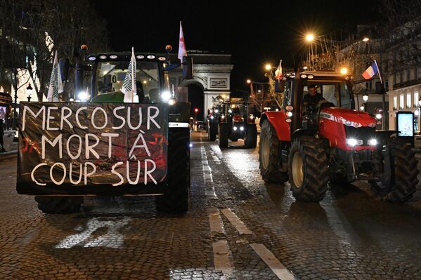 مزارعون يقودون جراراتهم في شارع الشانزليزيه احتجاجًا على اتفاقية التجارة بين دول المخروط الجنوبي (ميركوسور). يوم الثلاثاء 13 يناير/كانون الثاني 2026 في باريس. - سبوتنيك عربي