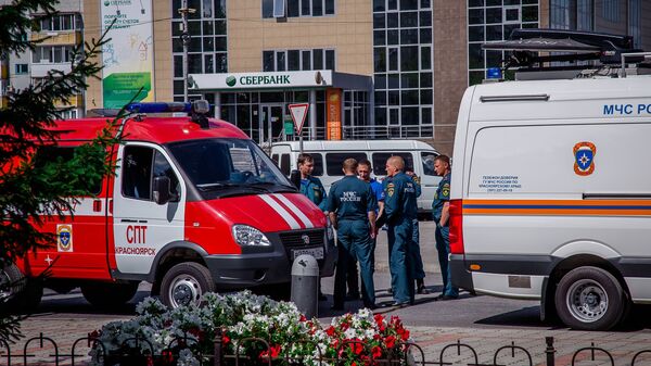 Russian Emergency Situation Ministry officers wait near their cars in the town of Achinsk, some 150 km west of Krasnoyarsk, Russia. The fire hit ammunition depot at a military base outside the town on August 5 leaving leaving 12 people injured - سبوتنيك عربي
