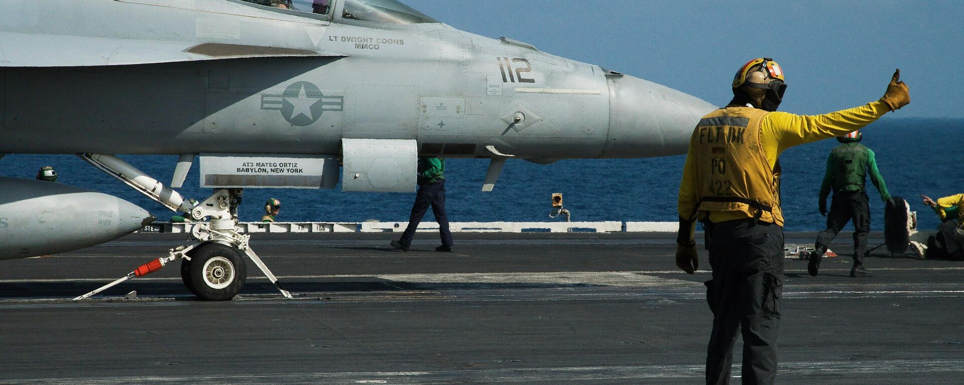 A crew member signals as a pilot prepares to launch an F/A-18 fighter jet on the deck of the USS Abraham Lincoln aircraft carrier in the Arabian Sea. File photo. - سبوتنيك عربي, 1920, 14.01.2026