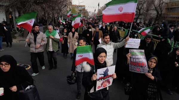 Люди несут иранские флаги и проправительственные плакаты в Тегеране, Иран - سبوتنيك عربي