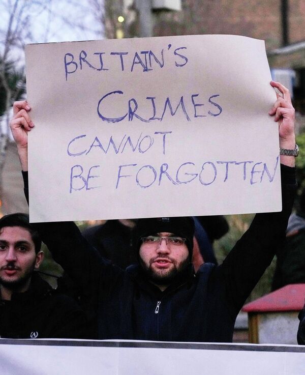 متظاهر مؤيد للحكومة الإيرانية يرفع لافتة مناهضة لبريطانيا أمام السفارة البريطانية في طهران - سبوتنيك عربي