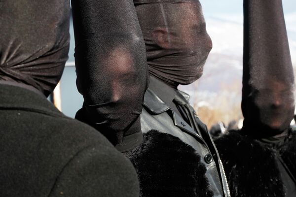 ينظر المحتفلون الذين يرتدون الأزياء التنكرية قبل موكب "الكرنفال"، في قرية فيفكاني في الجزء الجنوبي الغربي من مقدونيا الشمالية عشية عيد القديس باسيليوس الأرثوذكسي. - سبوتنيك عربي