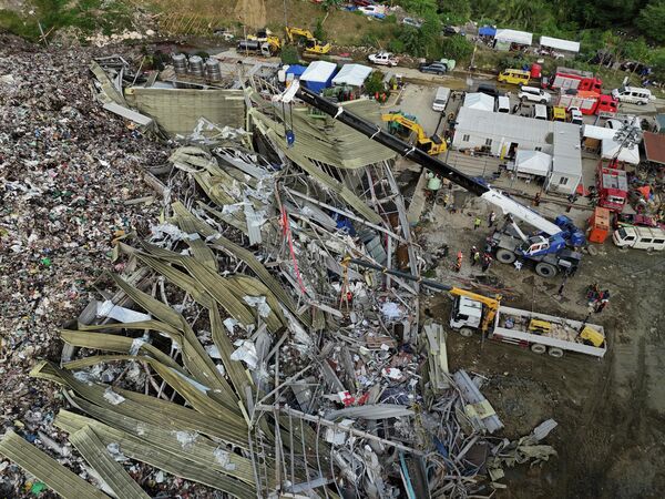 صورة تظهر مواصلة عمليات البحث والإنقاذ، عن العمال المفقودين في منشأة إدارة النفايات المنهارة في بيناليو، وسط الفلبين. - سبوتنيك عربي