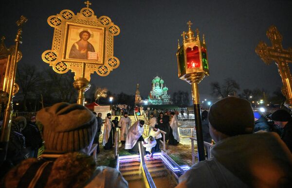 يؤدي رجال الدين طقوس مباركة الماء خلال الغطس في احتفالات عيد الغطاس التقليدية، في بركة "القصر الكبير" بالقرب من كنيسة الثالوث المقدس في منتزه "أوستانكينو" في موسكو - سبوتنيك عربي