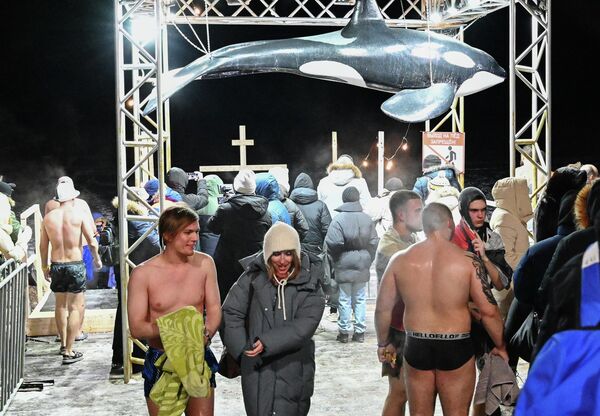 يقوم الناس بالغطس في المياه الجليدية خلال احتفالات عيد الغطاس التقليدية في ميناء "سبورتيفنايا" في مقاطعة فلاديفوستوك الروسية - سبوتنيك عربي